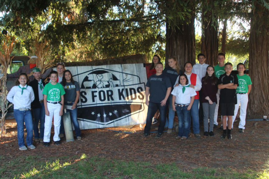 Solano County junior livestock exhibitors in front of Bids for Kids sign